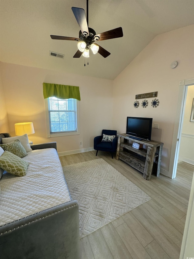 bedroom featuring visible vents, ceiling fan, baseboards, lofted ceiling, and wood finished floors