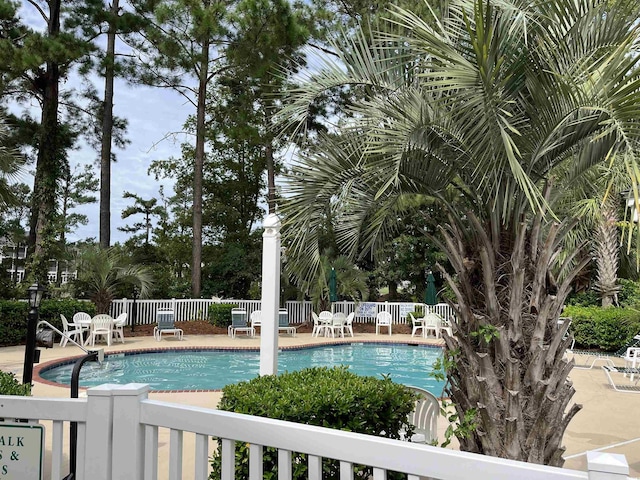 community pool featuring fence and a patio area