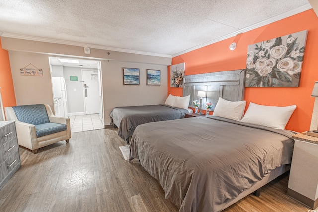 bedroom with a textured ceiling, wood finished floors, and ornamental molding