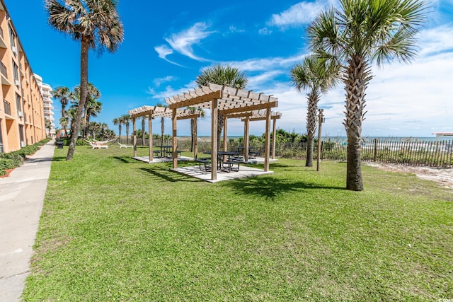 view of home's community with a patio area, a lawn, a pergola, and fence