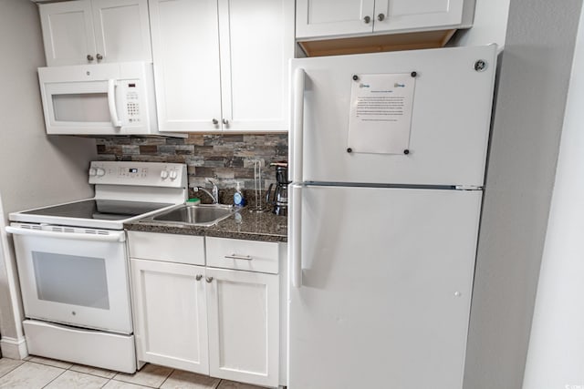 kitchen with white appliances, light tile patterned flooring, a sink, dark countertops, and backsplash