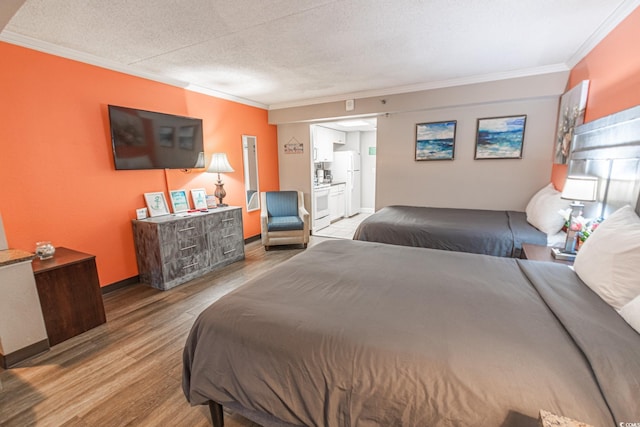 bedroom with ornamental molding, ensuite bathroom, a textured ceiling, wood finished floors, and freestanding refrigerator