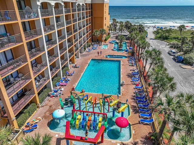 view of swimming pool featuring a view of the beach and a water view