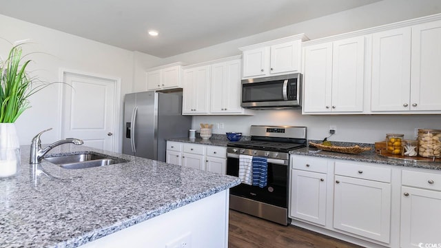 kitchen featuring white cabinets, appliances with stainless steel finishes, dark hardwood / wood-style floors, and sink