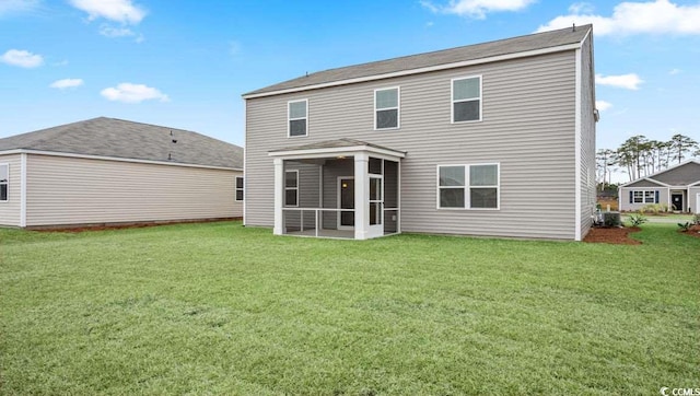 back of house featuring a yard and a sunroom