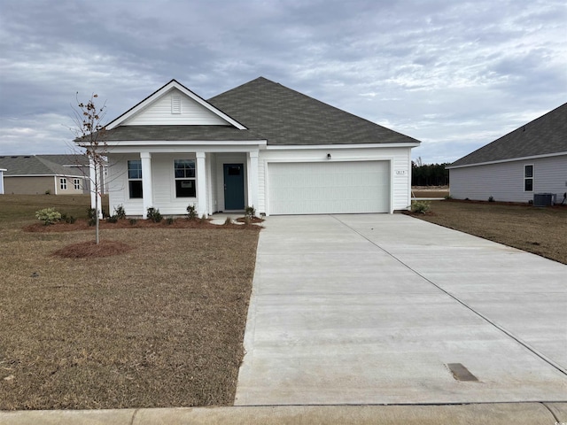 view of front of home featuring a front lawn, central AC unit, and a garage