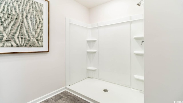 bathroom featuring hardwood / wood-style flooring and walk in shower