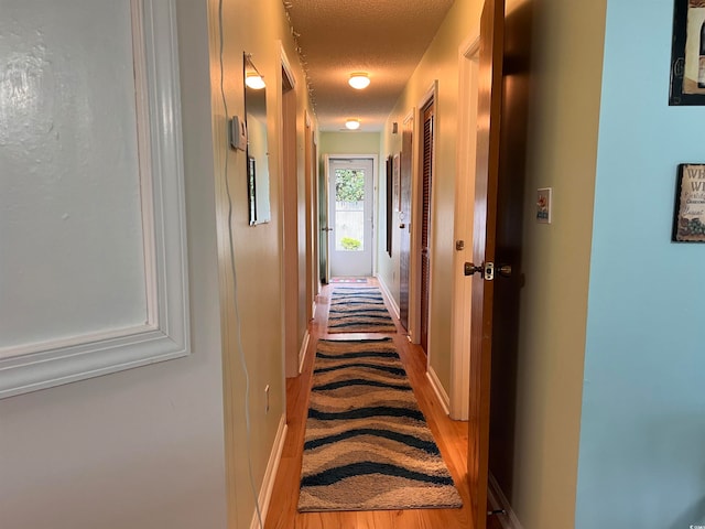 hallway featuring a textured ceiling and wood-type flooring