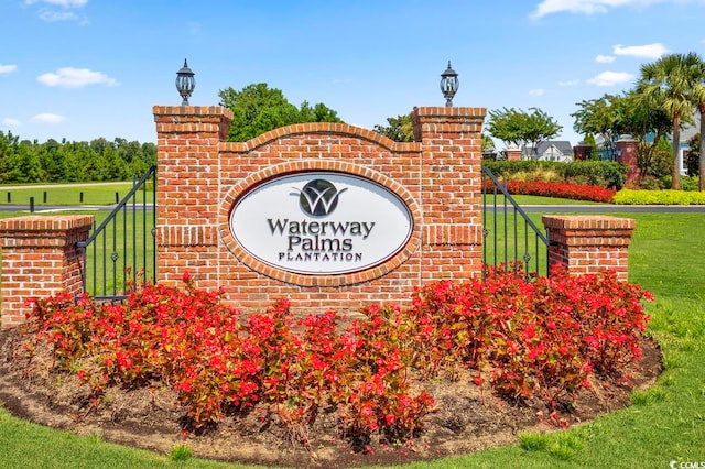 community / neighborhood sign featuring a yard