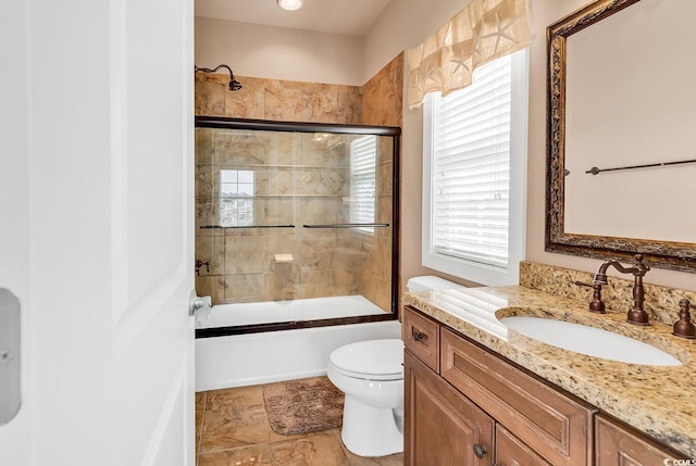 full bathroom featuring toilet, bath / shower combo with glass door, and vanity