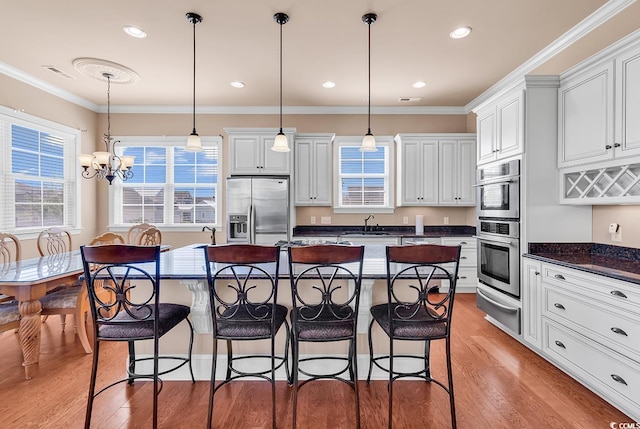 kitchen with hardwood / wood-style floors, a kitchen island, stainless steel appliances, and pendant lighting