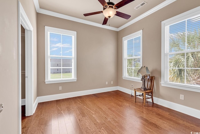 empty room with crown molding, wood-type flooring, and ceiling fan