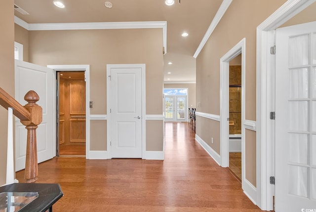 entrance foyer with light wood-type flooring, french doors, and crown molding