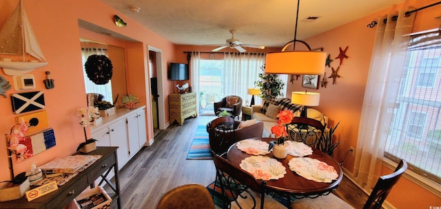 dining space featuring ceiling fan and dark wood-type flooring