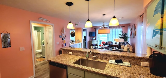 kitchen with light hardwood / wood-style floors, light stone countertops, dishwasher, decorative light fixtures, and sink