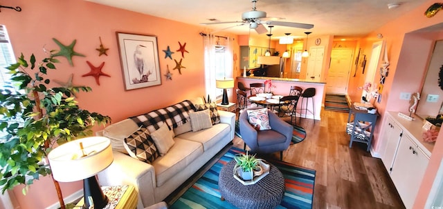 living room featuring a healthy amount of sunlight, ceiling fan, and hardwood / wood-style flooring