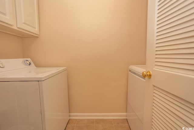 laundry area with light tile patterned floors and cabinets