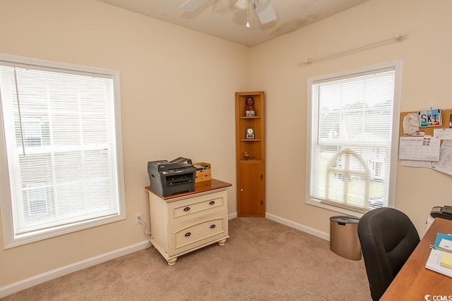 carpeted office space featuring ceiling fan