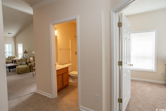 corridor featuring lofted ceiling and light colored carpet