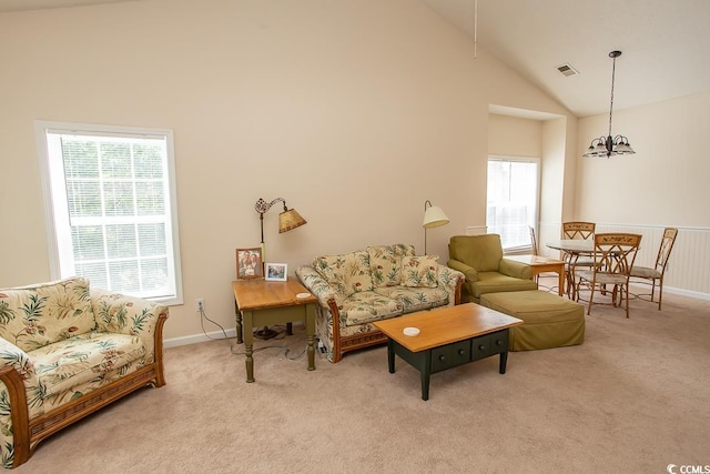 living room featuring plenty of natural light, high vaulted ceiling, and light colored carpet