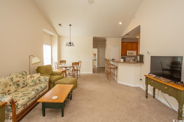 living room featuring a notable chandelier, lofted ceiling, and light colored carpet