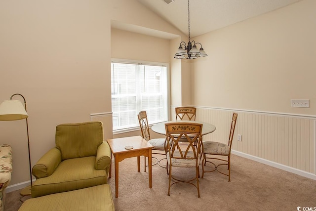 dining area with vaulted ceiling, a notable chandelier, and light carpet