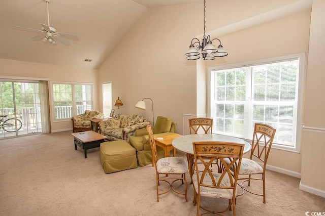 dining space featuring lofted ceiling, ceiling fan with notable chandelier, and light colored carpet