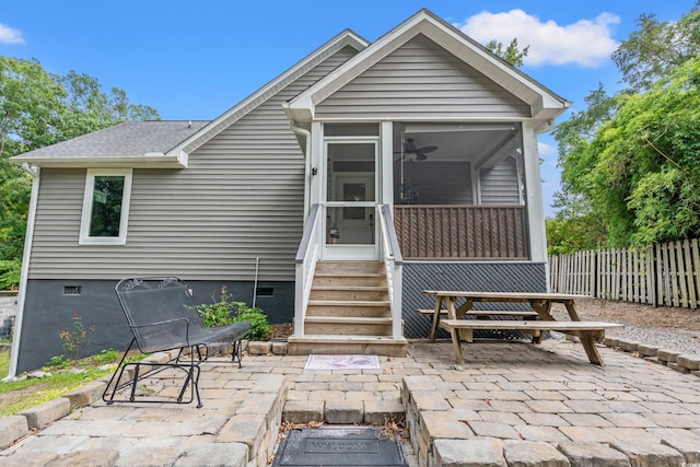 rear view of house with a sunroom, ceiling fan, and a patio