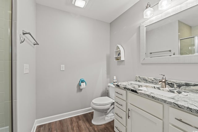 bathroom with hardwood / wood-style floors, walk in shower, toilet, and vanity