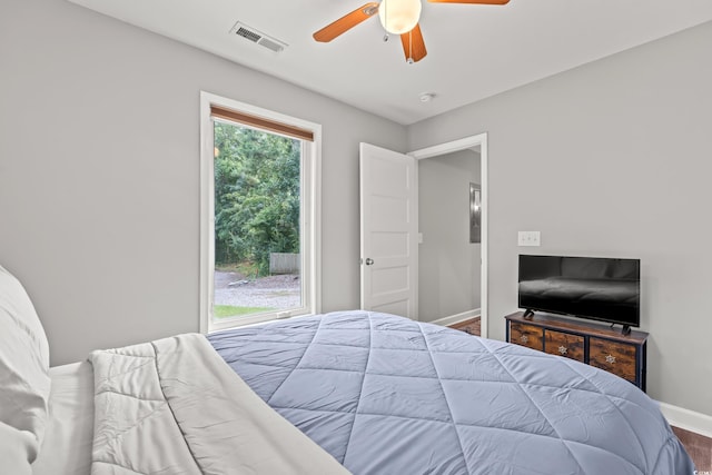 bedroom featuring multiple windows, hardwood / wood-style floors, and ceiling fan