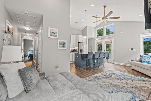 living room with ceiling fan, hardwood / wood-style floors, high vaulted ceiling, and french doors