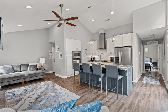 living room with light wood-type flooring, high vaulted ceiling, and ceiling fan