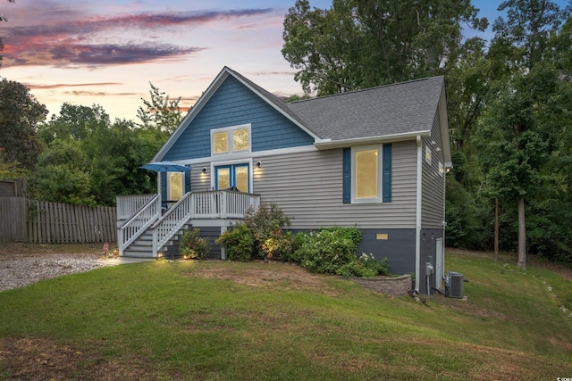 view of front of home with a lawn and central AC unit