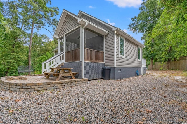 view of home's exterior with a sunroom and a patio