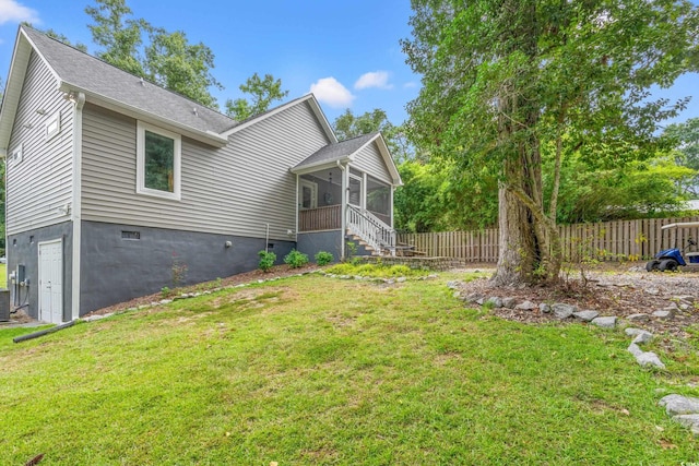 view of side of property with central AC unit, a sunroom, and a lawn