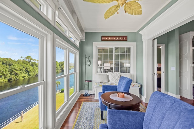 sunroom / solarium with a water view and ceiling fan