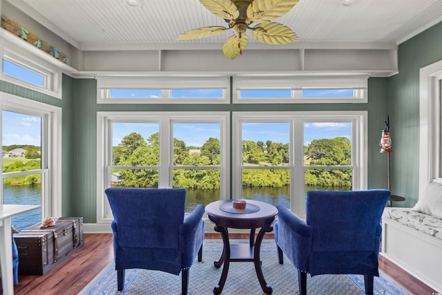 sitting room featuring ceiling fan, hardwood / wood-style flooring, a water view, and a wealth of natural light