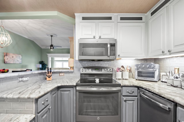 kitchen with appliances with stainless steel finishes, tasteful backsplash, white cabinets, gray cabinets, and ceiling fan