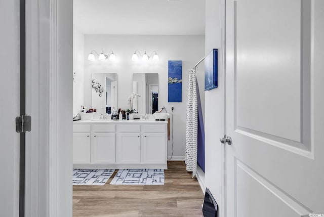 bathroom with curtained shower, hardwood / wood-style flooring, and vanity