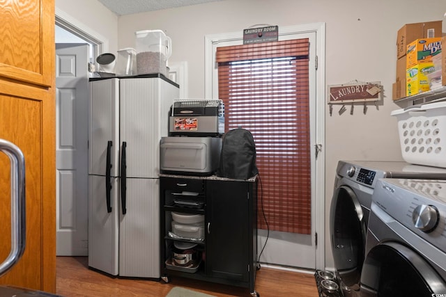 laundry area with independent washer and dryer and hardwood / wood-style flooring