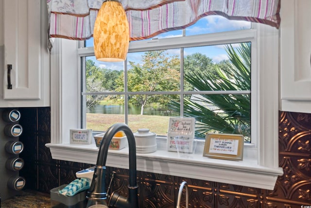 interior details featuring a water view and white cabinetry