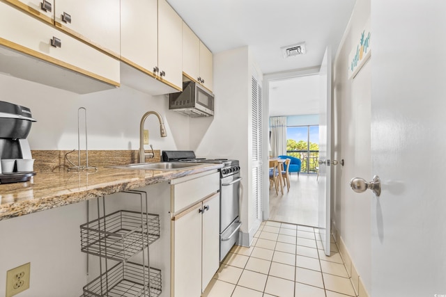 kitchen with a breakfast bar, light stone counters, appliances with stainless steel finishes, and white cabinetry