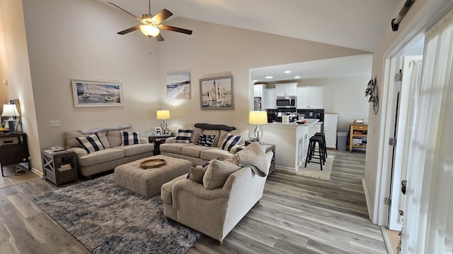 living room featuring ceiling fan, wood-type flooring, and high vaulted ceiling