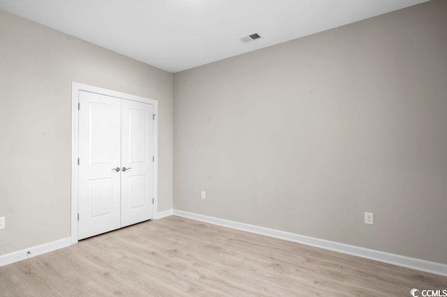 unfurnished bedroom featuring a closet and light hardwood / wood-style floors