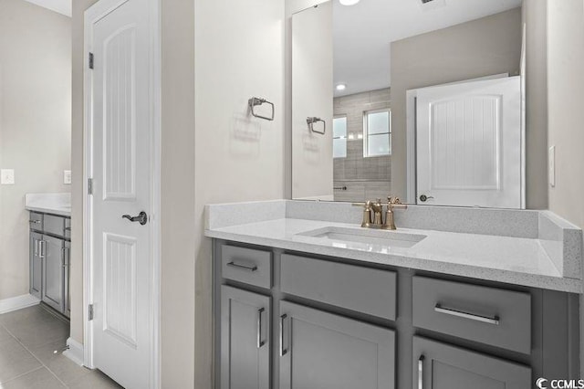 bathroom featuring a tile shower, tile patterned flooring, and vanity