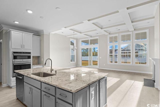 kitchen with a center island with sink, light hardwood / wood-style flooring, a wealth of natural light, and sink