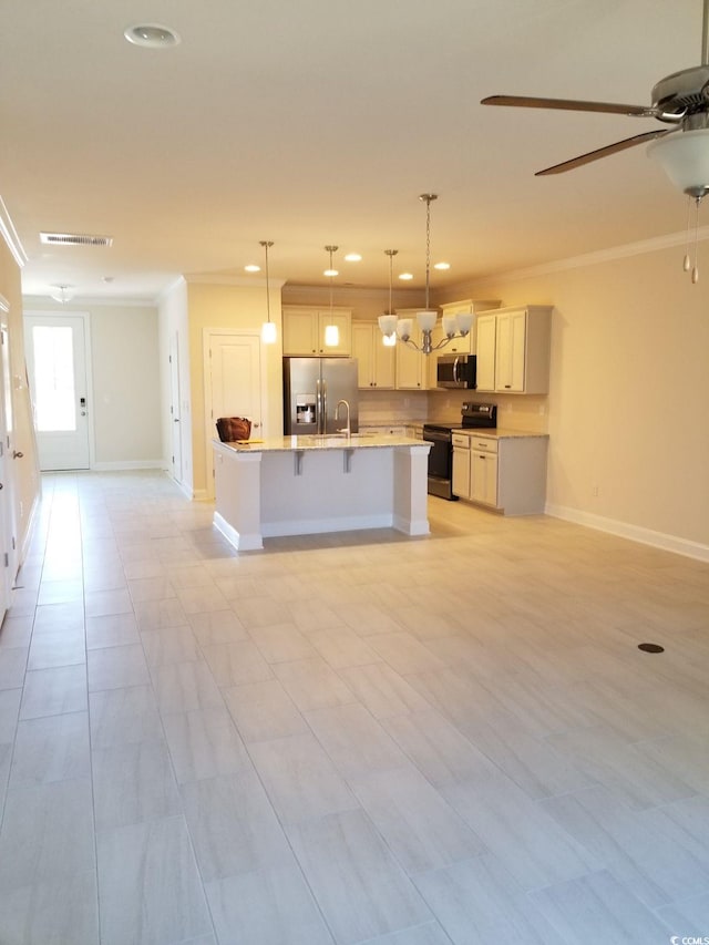 kitchen featuring crown molding, stainless steel appliances, an island with sink, and hanging light fixtures