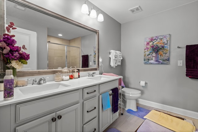 bathroom with vanity, toilet, a shower with shower door, and tile patterned flooring