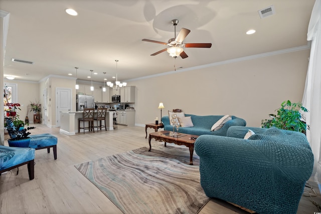 living room with ornamental molding, ceiling fan with notable chandelier, and light wood-type flooring