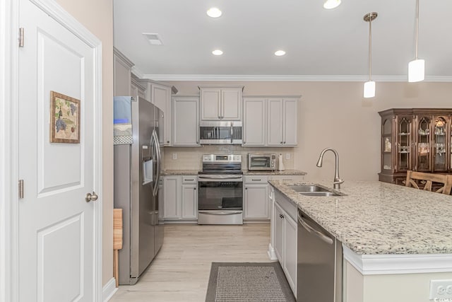 kitchen with sink, crown molding, an island with sink, stainless steel appliances, and light hardwood / wood-style floors